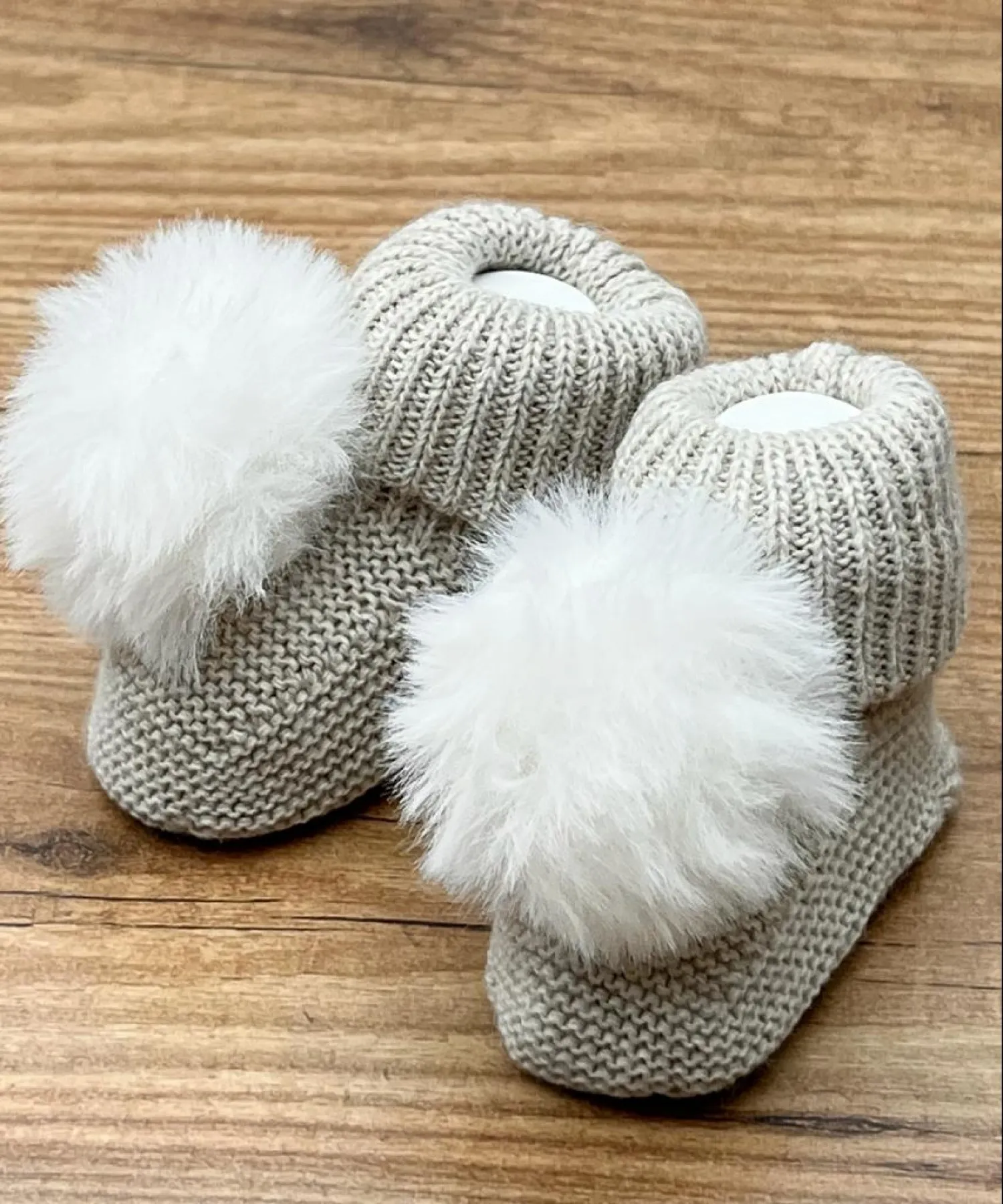 Chubby knit bootees with a fur pompom. Adriatic Collection